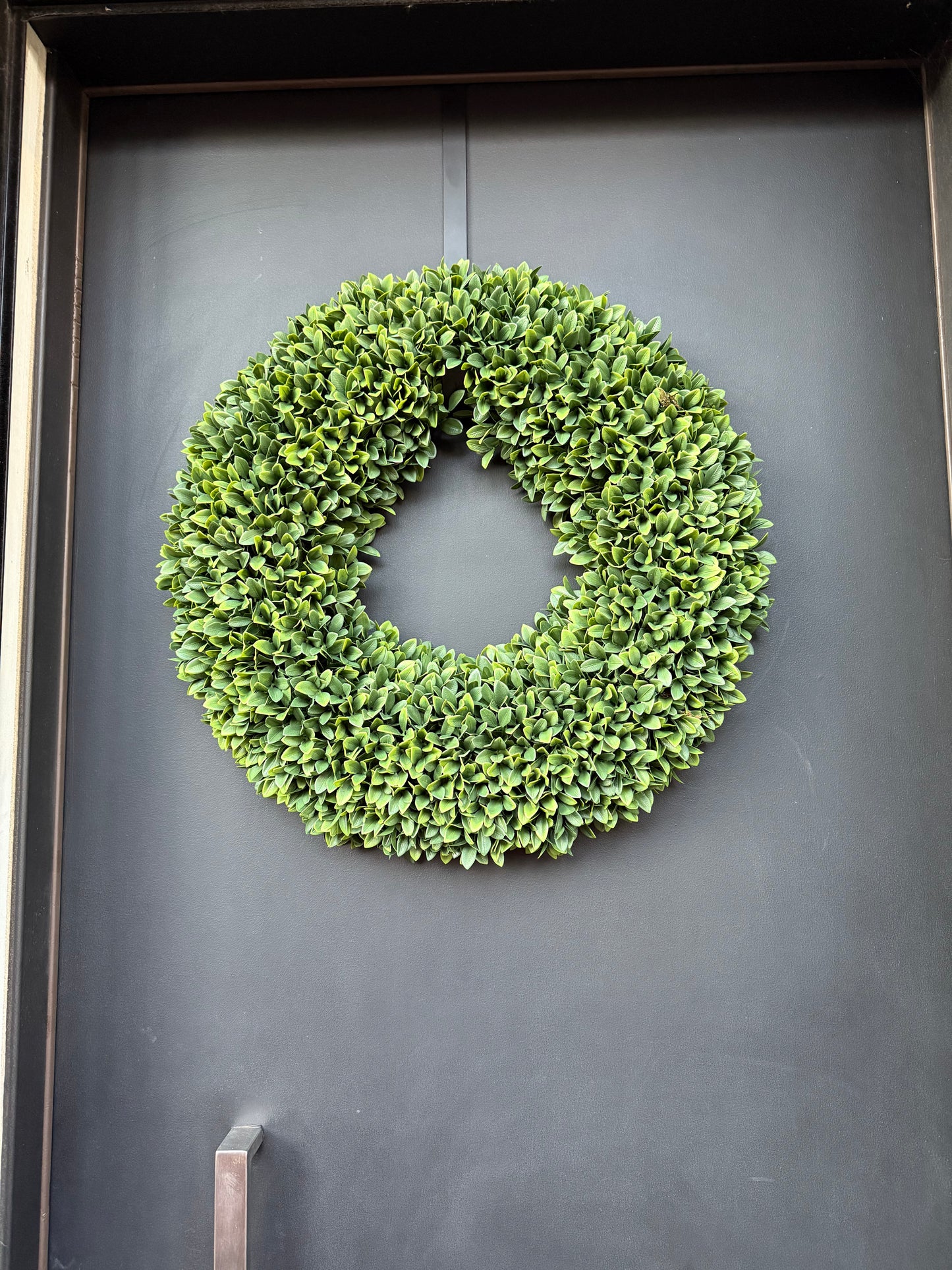 Boxwood wreath on a dark gray surface