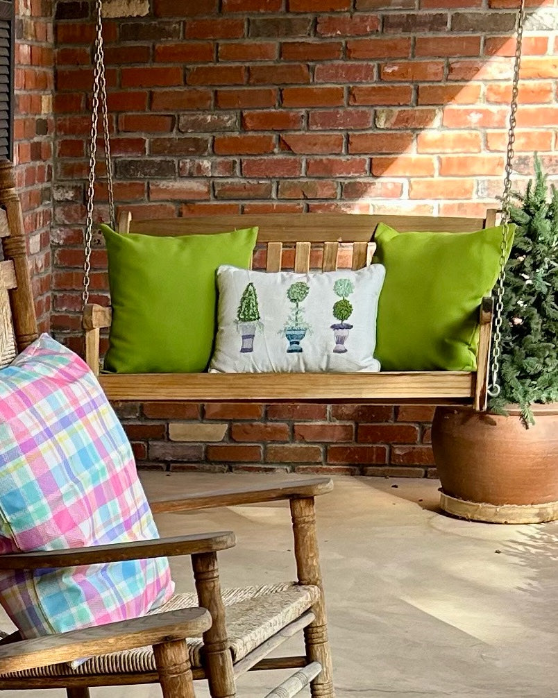 Front porch decorated for spring with seasonal pillows