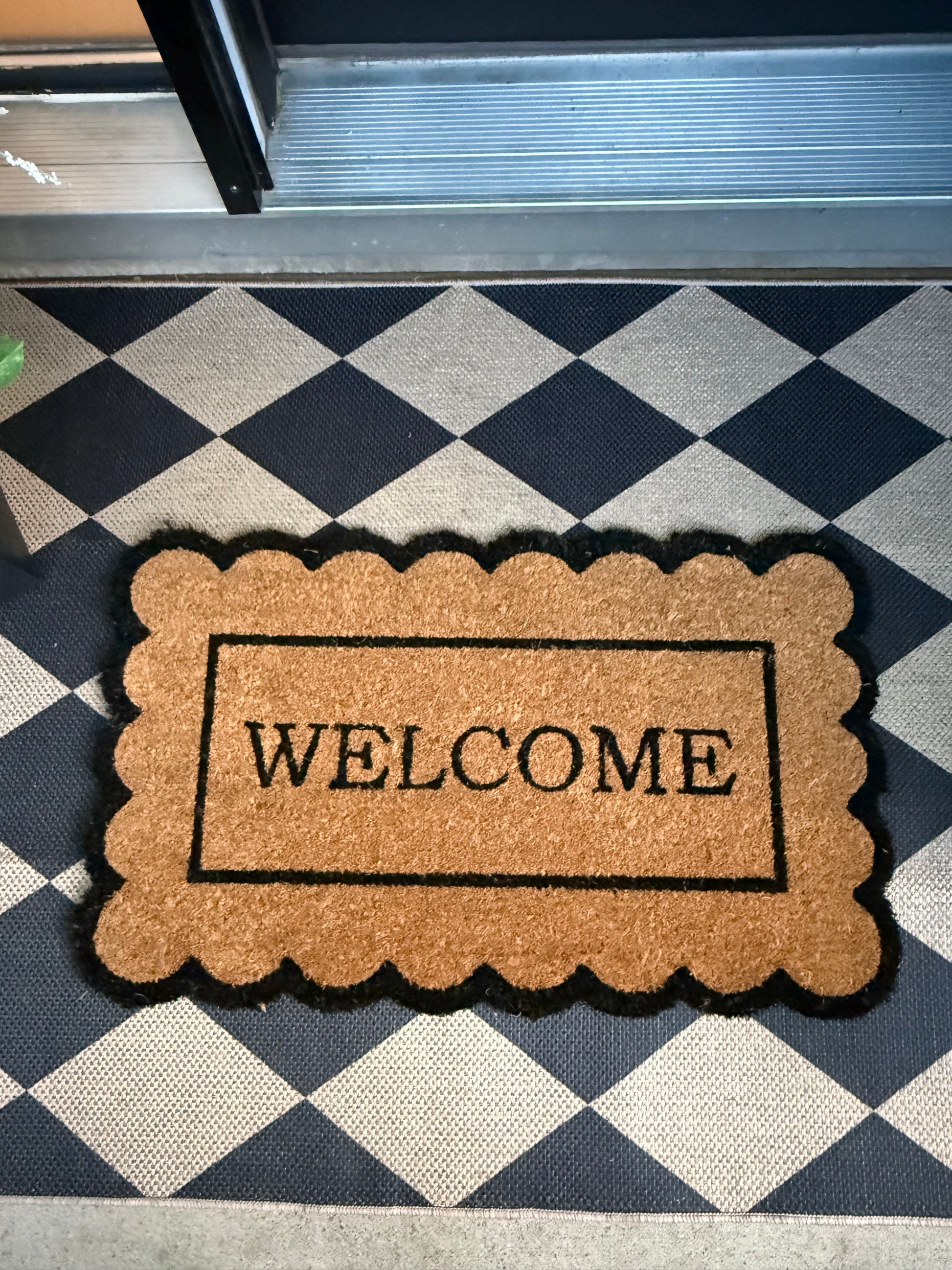 Doormat with 'WELCOME' text on a checkered floor