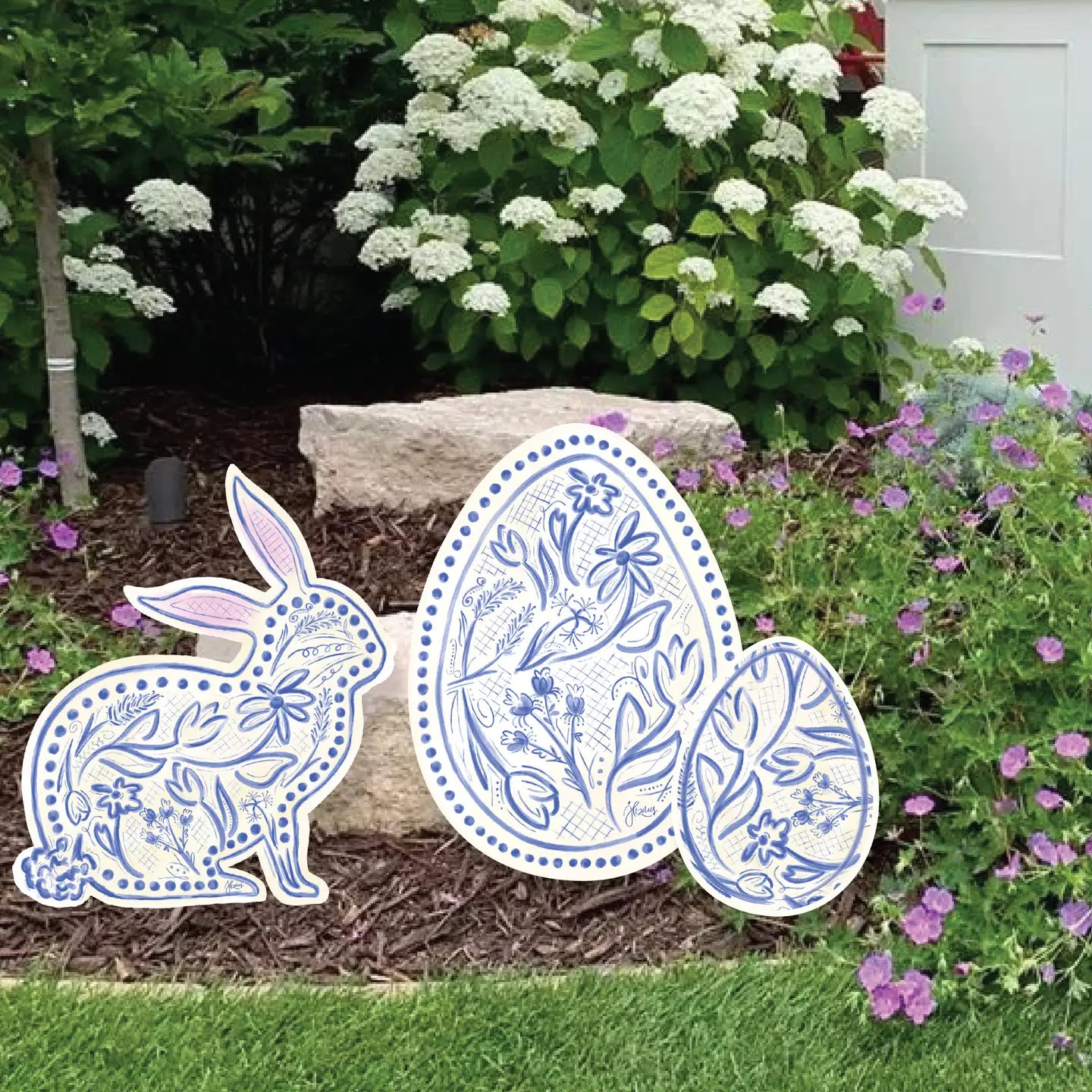  Yard art set consisting of a blue and white chinoiserie styled bunny and Easter egg, placed outdoors among garden plants.